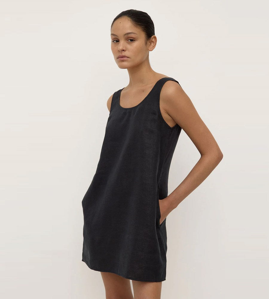 Woman wearing a black sleeveless dress against a white background