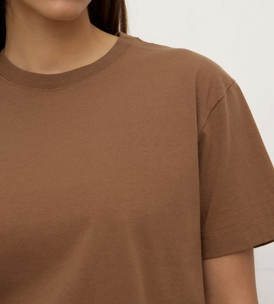 Brown t-shirt worn by a person on a plain background