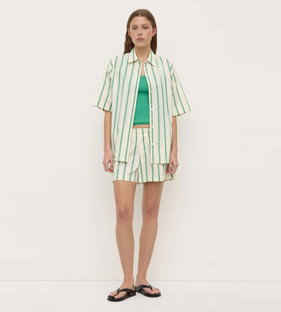 Woman wearing a green and white striped outfit on a white background