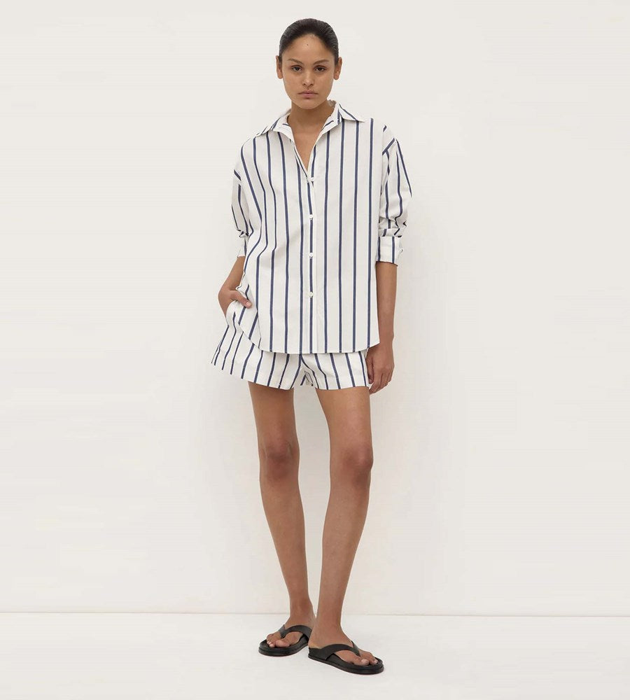 Person wearing a black and white striped shirt and shorts set on a white background