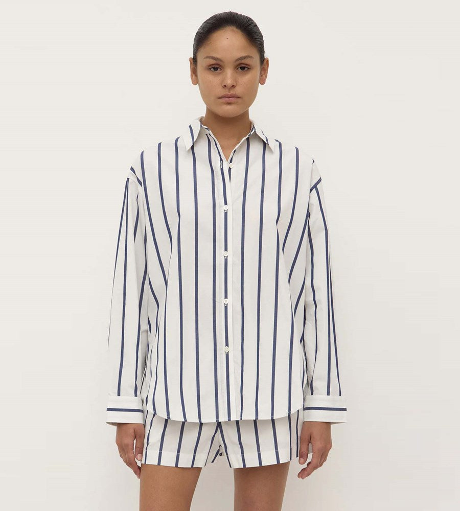 Person wearing a white and navy striped shirt and shorts set on a white background
