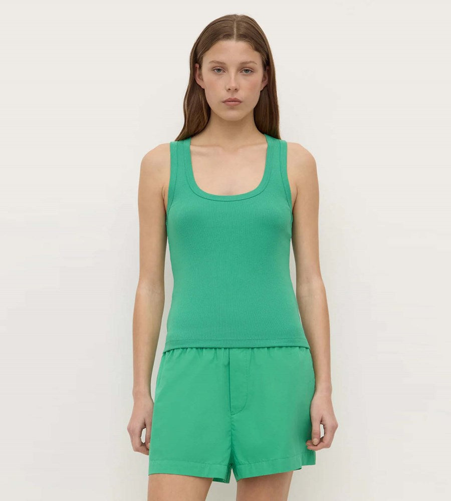 Woman wearing a green tank top and shorts set on a white background