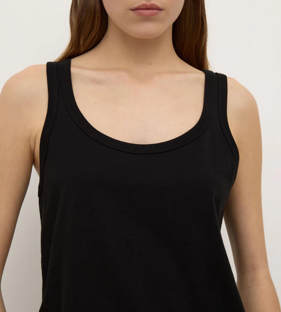 Black tank top worn by a person on a plain background