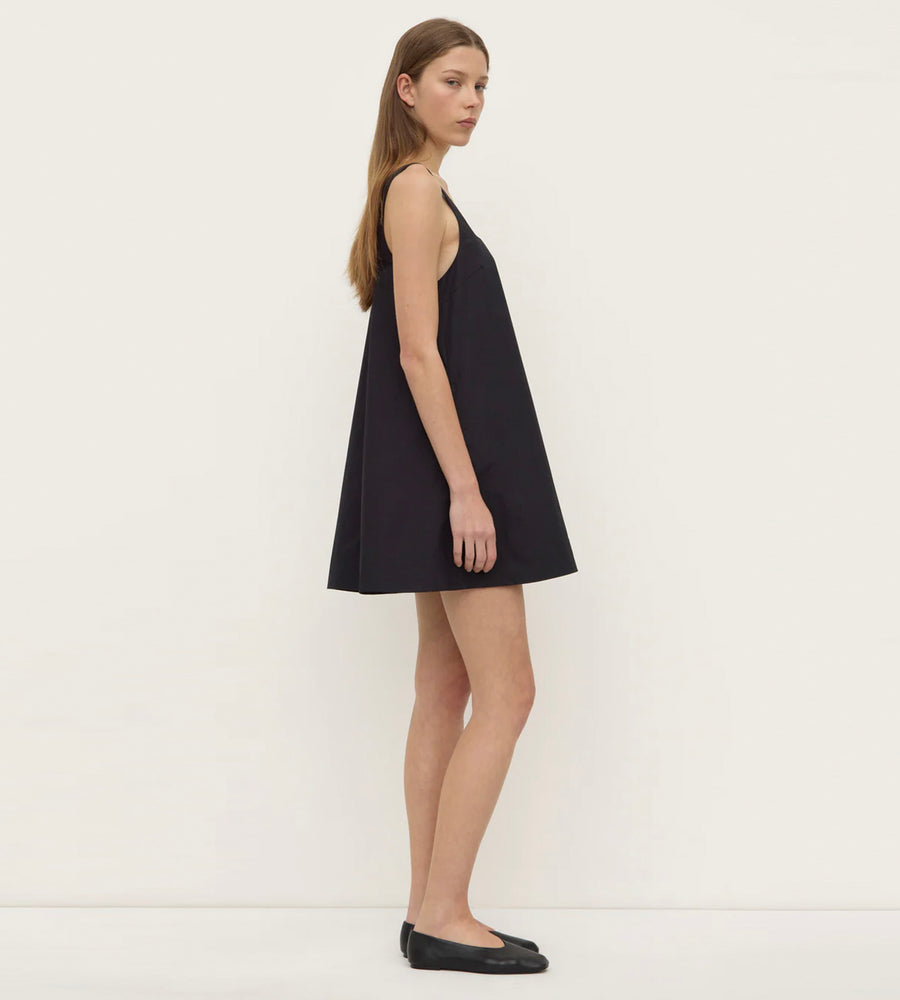 Woman wearing a black dress against a white background