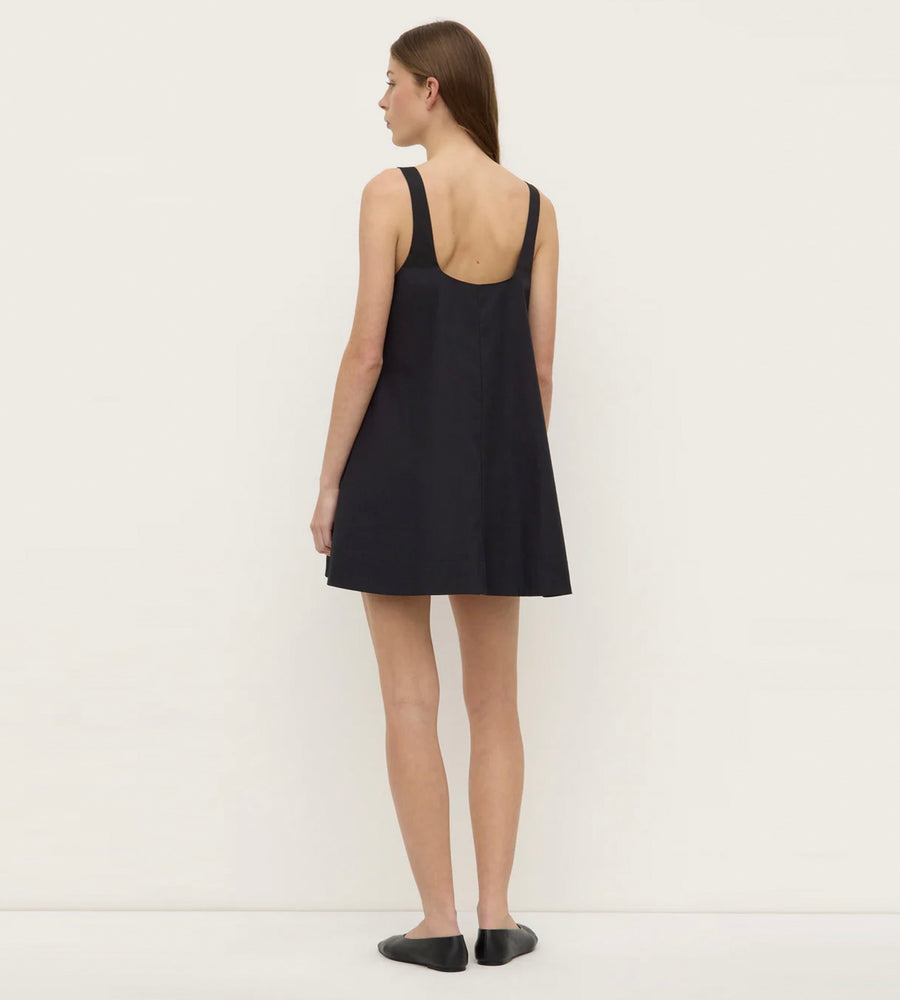 Woman wearing a black sleeveless dress against a white background
