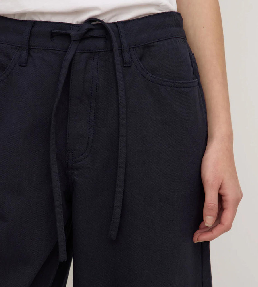 Navy blue pants with a tie waist on a plain background