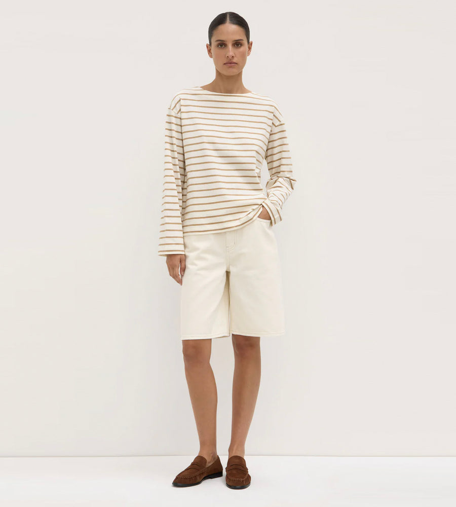 Person wearing a striped shirt and white skirt on a plain background