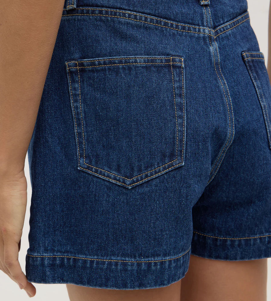 Close-up of blue denim shorts on a plain background