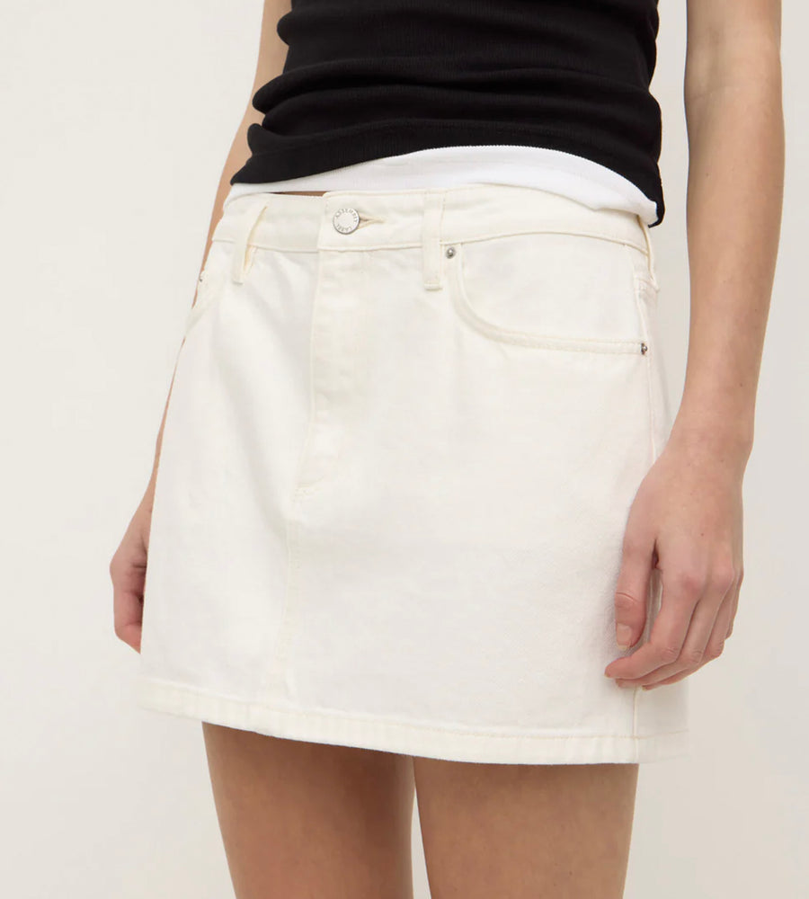 White denim skirt worn by a person on a plain background