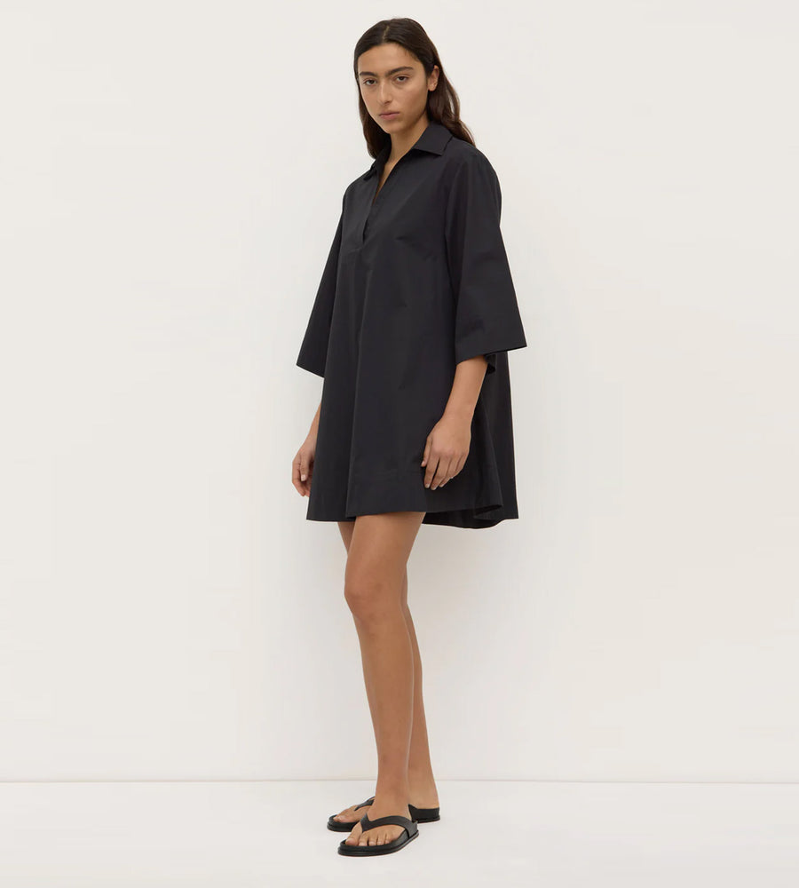 Woman wearing a black dress against a white background
