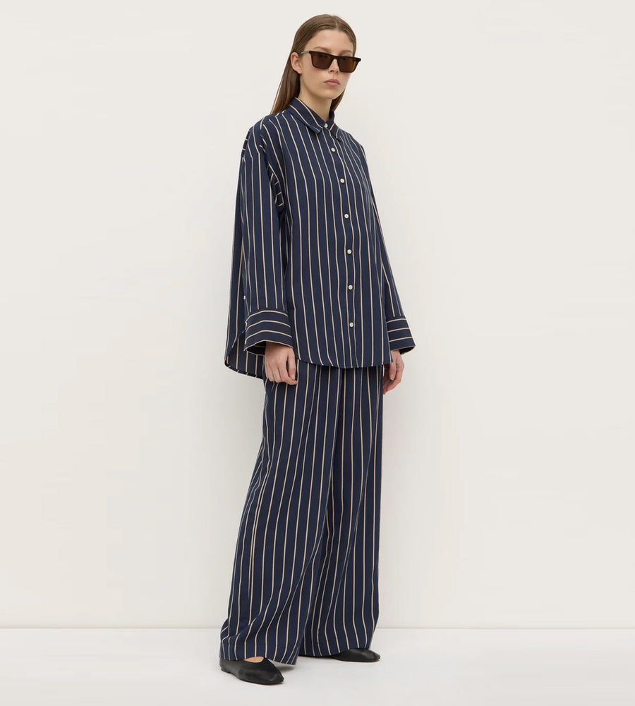Person wearing a navy striped outfit on a white background