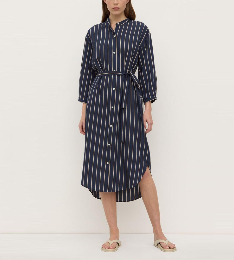 Woman wearing a navy and white striped dress on a white background