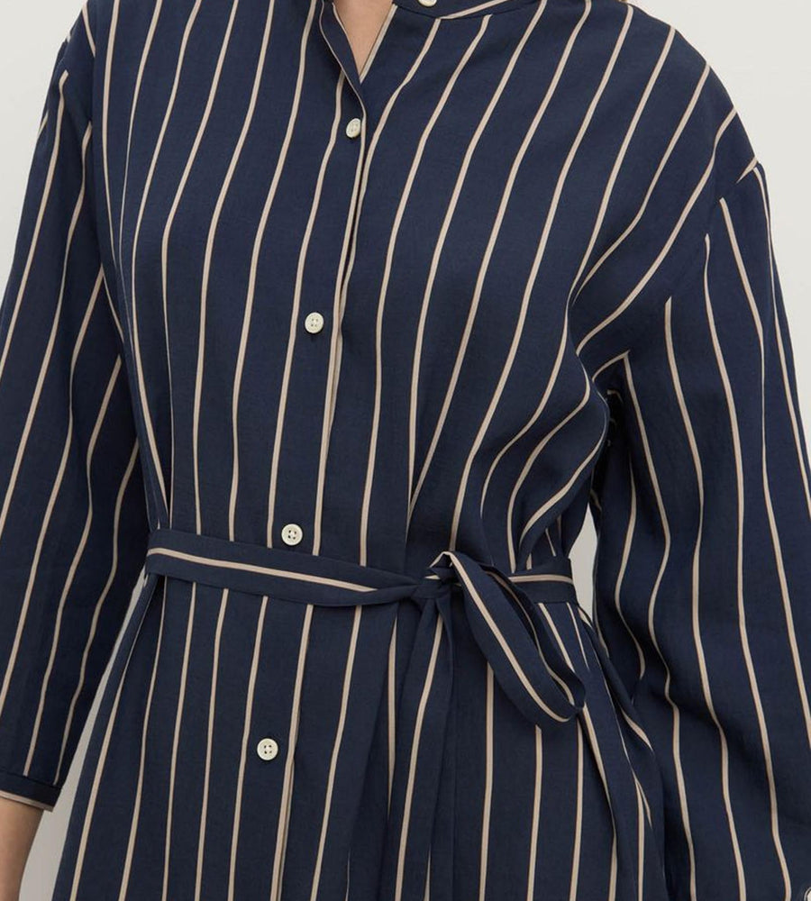 Navy pinstripe dress with buttons on a plain background
