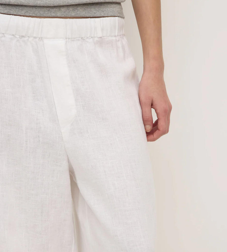 White pants worn by a person on a plain background
