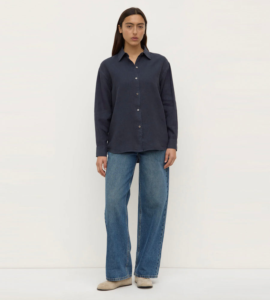 Person wearing a dark blue shirt and jeans on a white background