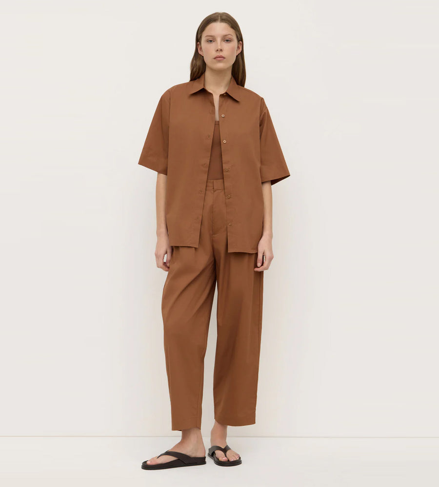 Person wearing a brown outfit against a white background