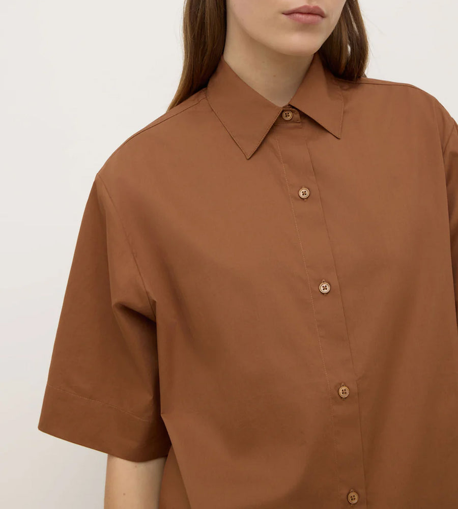 Brown shirt worn by a person on a white background