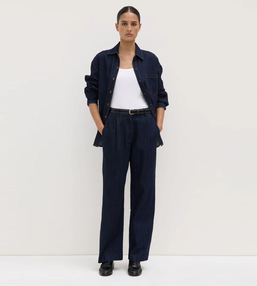 Person wearing a navy outfit with a white shirt on a plain background