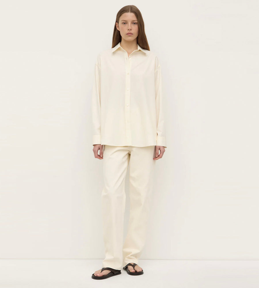 Person wearing a cream-colored outfit on a white background