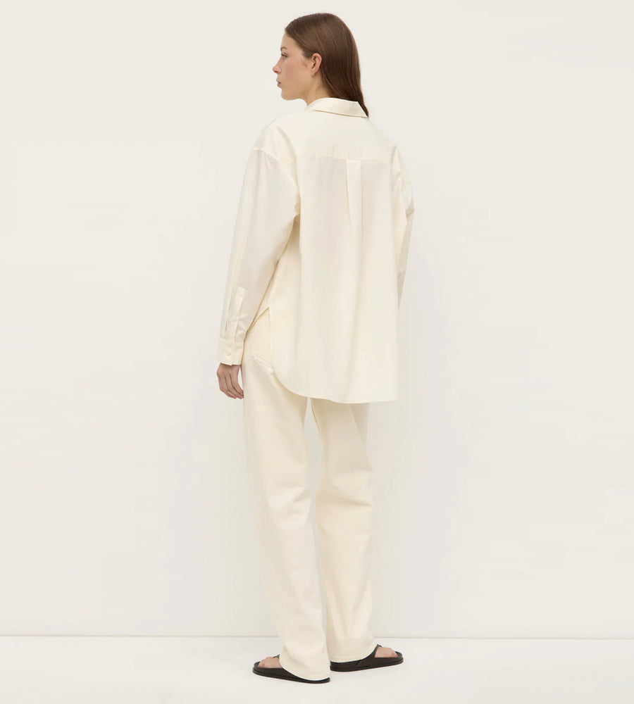 Person wearing a cream-colored suit on a white background