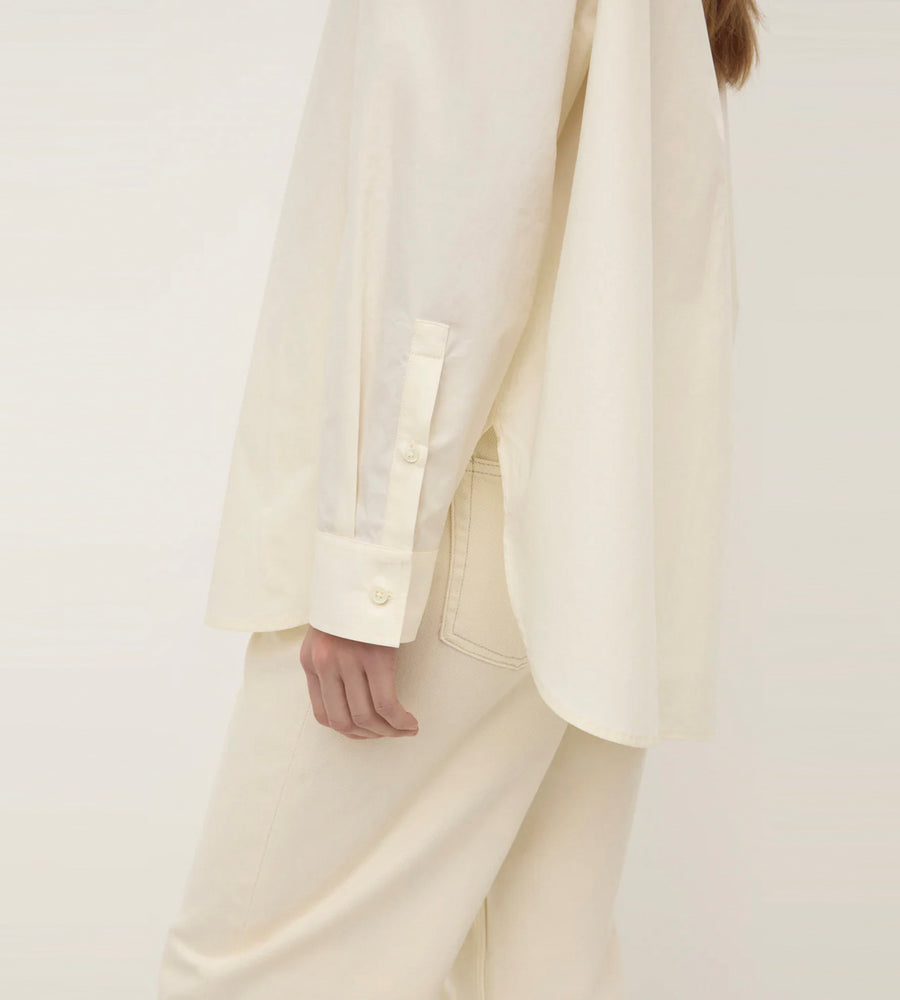 Person wearing a white suit on a plain background