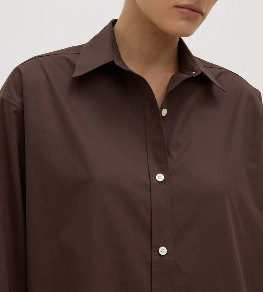 Close-up of a brown shirt with a plain background