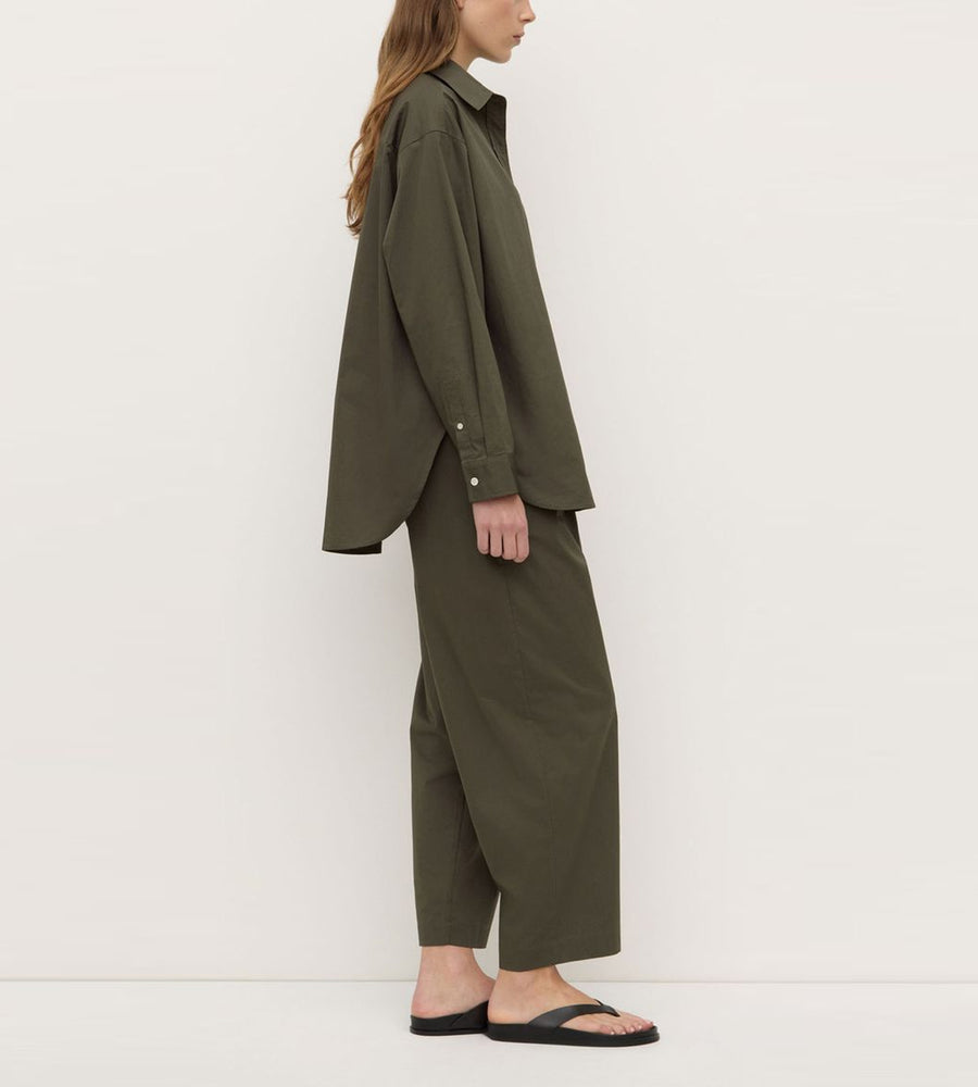 Person wearing a green outfit against a white background