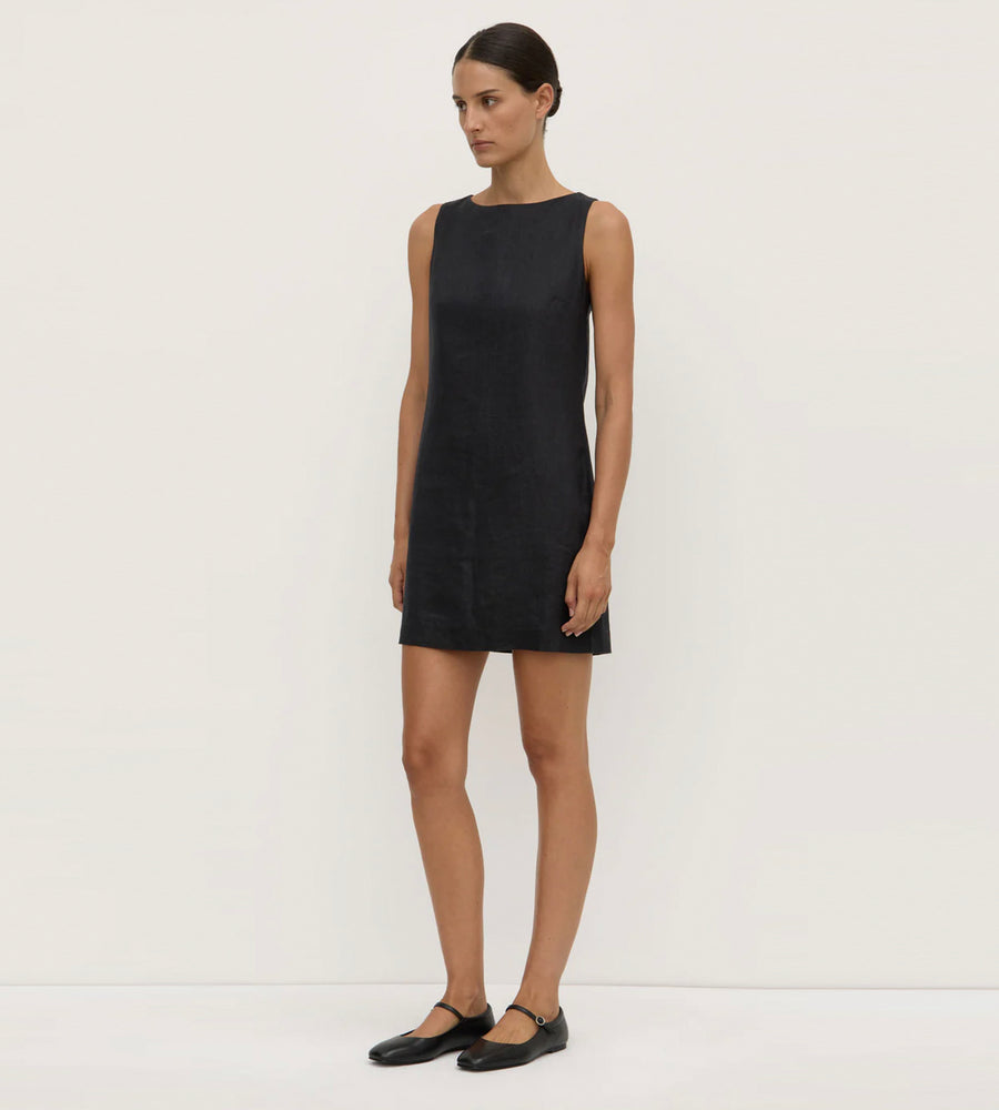 Woman wearing a black sleeveless dress against a white background