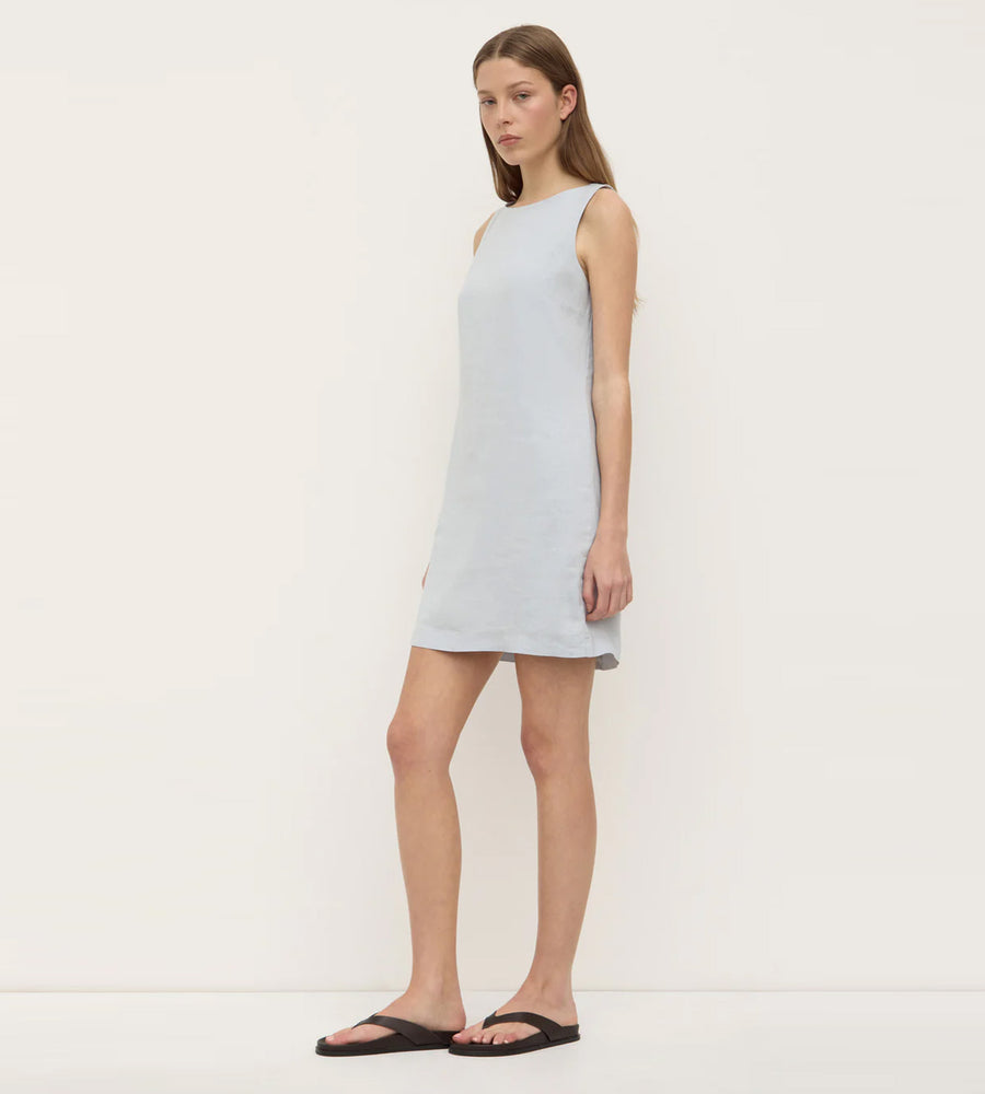 Woman wearing a light blue sleeveless dress on a white background
