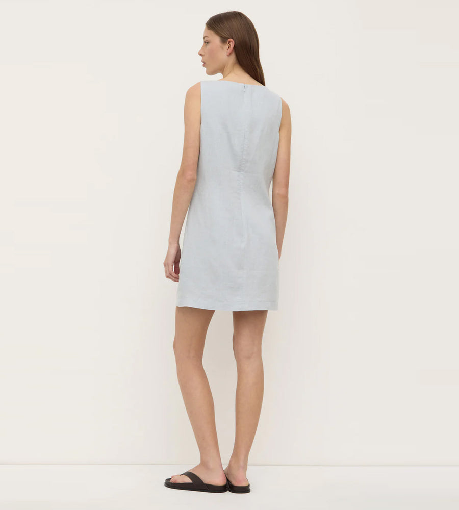 Woman wearing a light blue dress against a white background