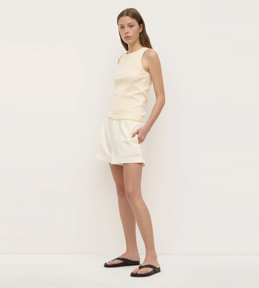Woman wearing a light-colored dress against a plain background