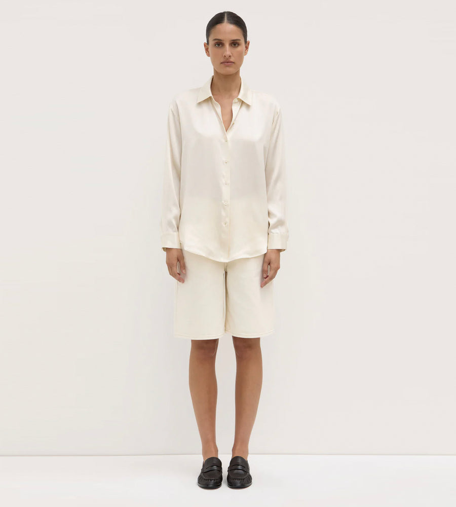 Person wearing a white shirt and pants on a plain background