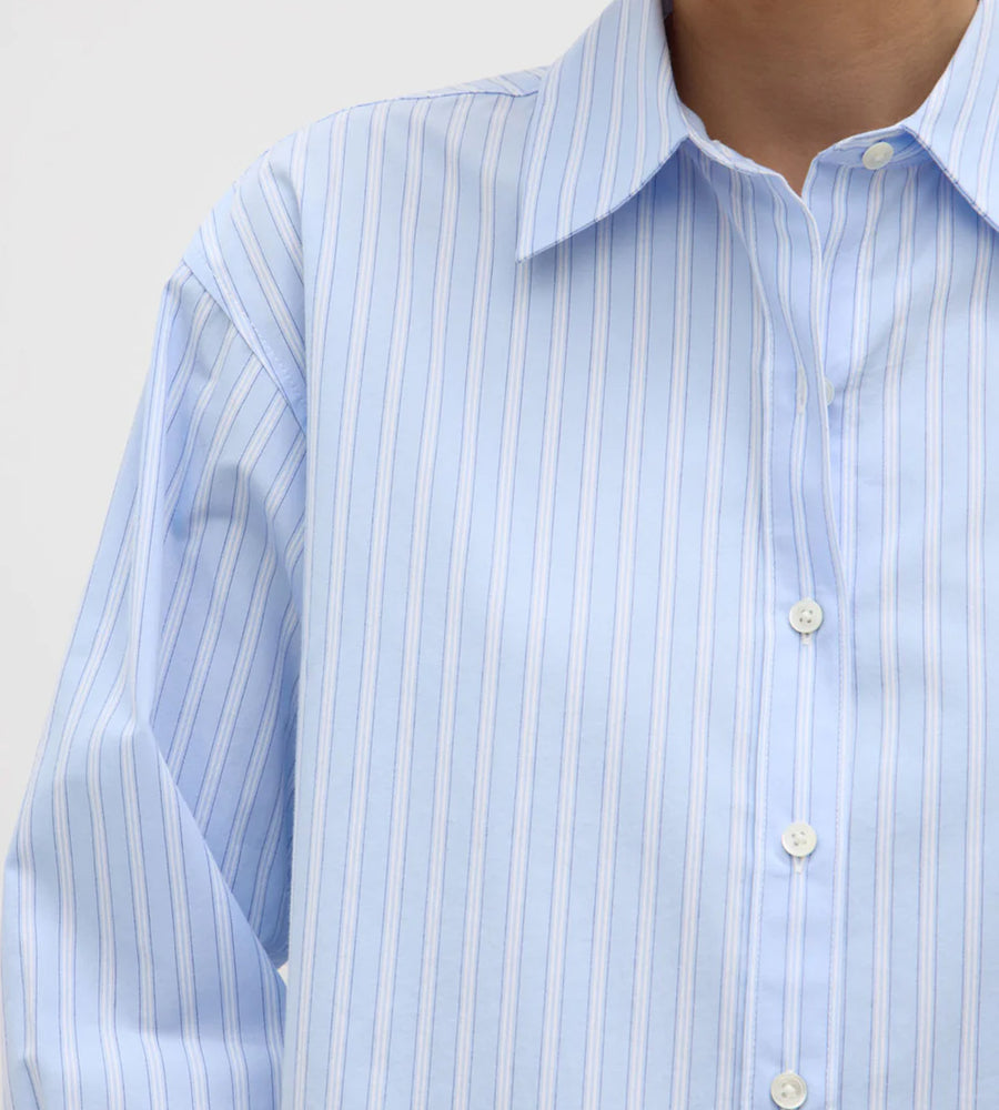 Close-up of a light blue striped shirt with a plain background