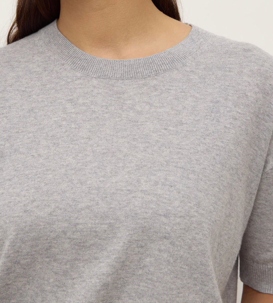 Gray short-sleeve shirt worn by a person on a white background