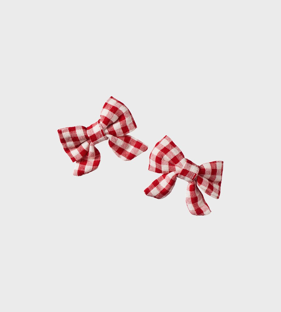 Two red and white checkered bows on a light gray background
