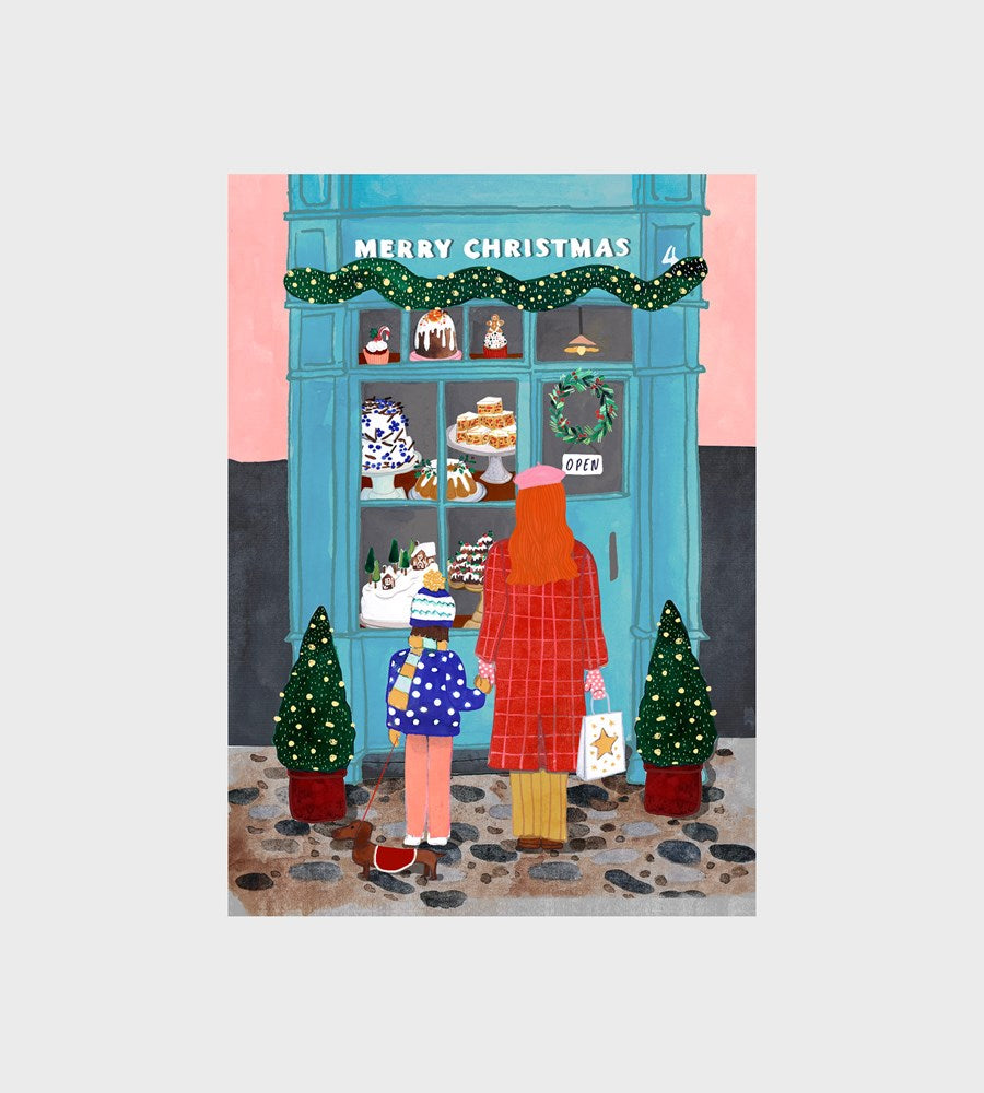 Illustration of a woman and child in front of a Christmas-themed cake shop with 'Merry Christmas' sign.