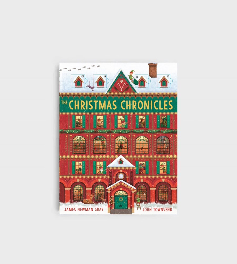 Book cover of 'The Christmas Chronicles' with a festive building illustration on a white background