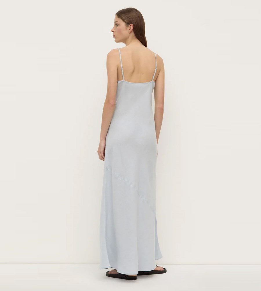 Woman wearing a light blue slip dress on a white background
