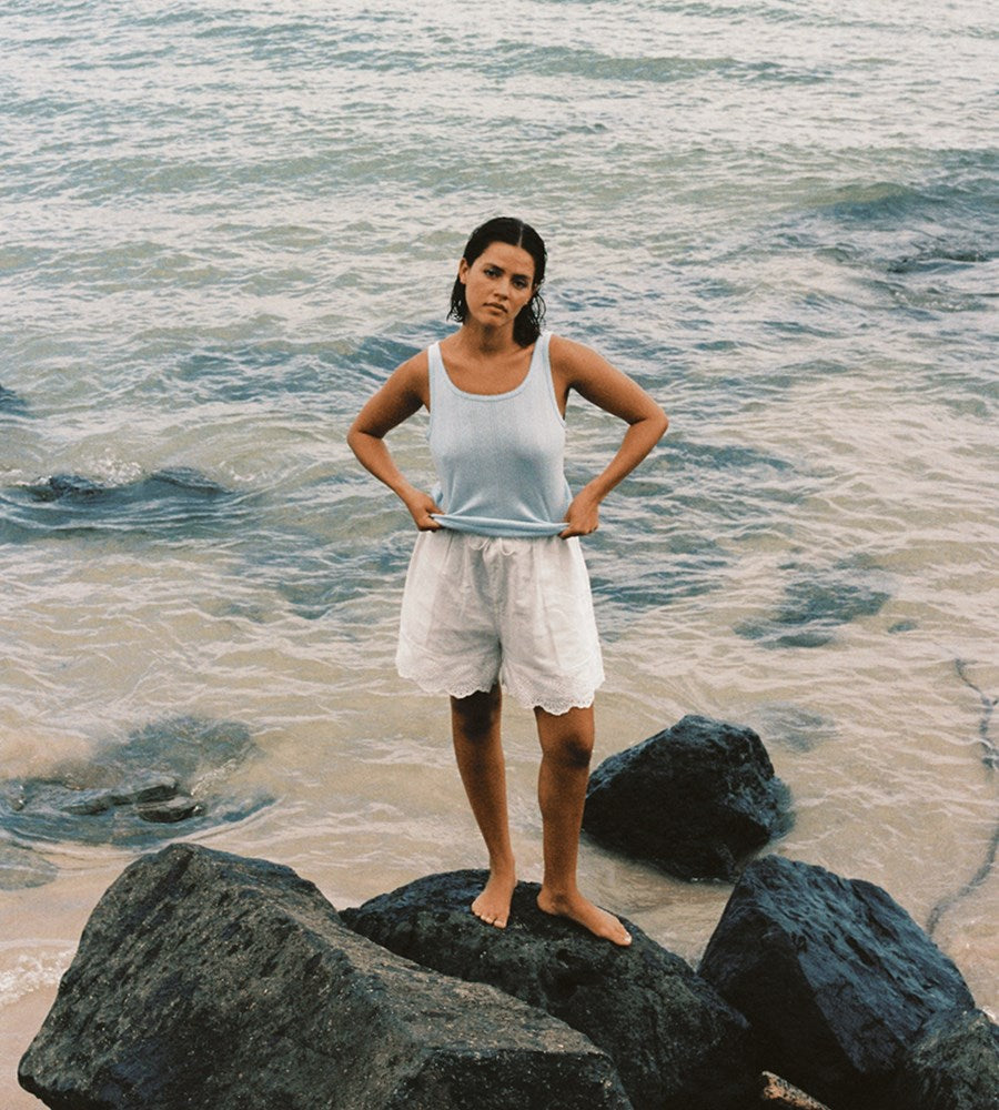 Woman standing on rocks by the ocean