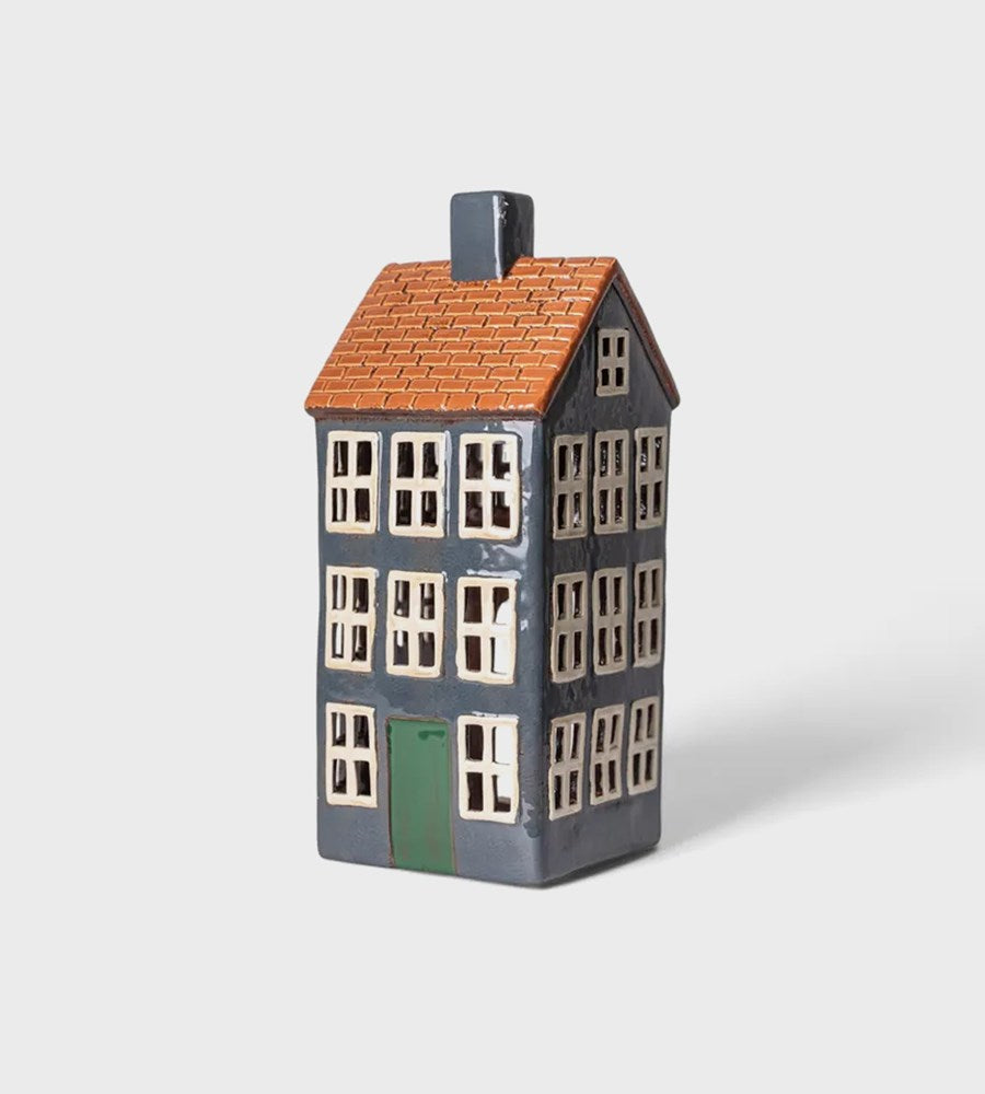Ceramic house-shaped vase with a gray base, orange roof, and white windows on a light gray background
