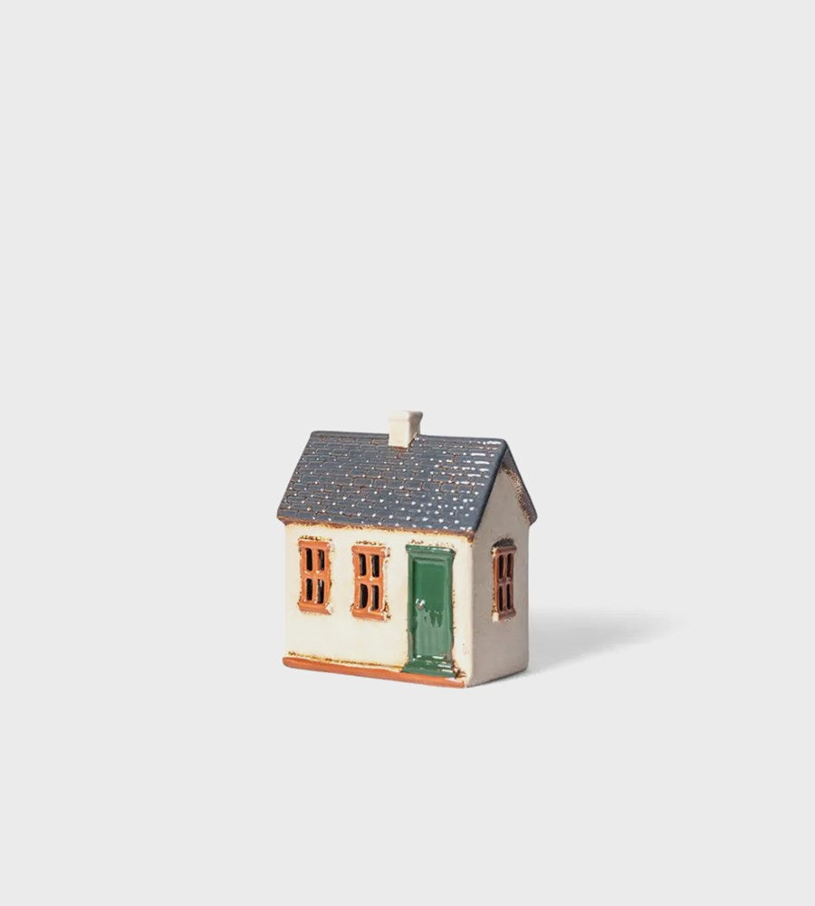 Small model of a house with a green door on a light gray background