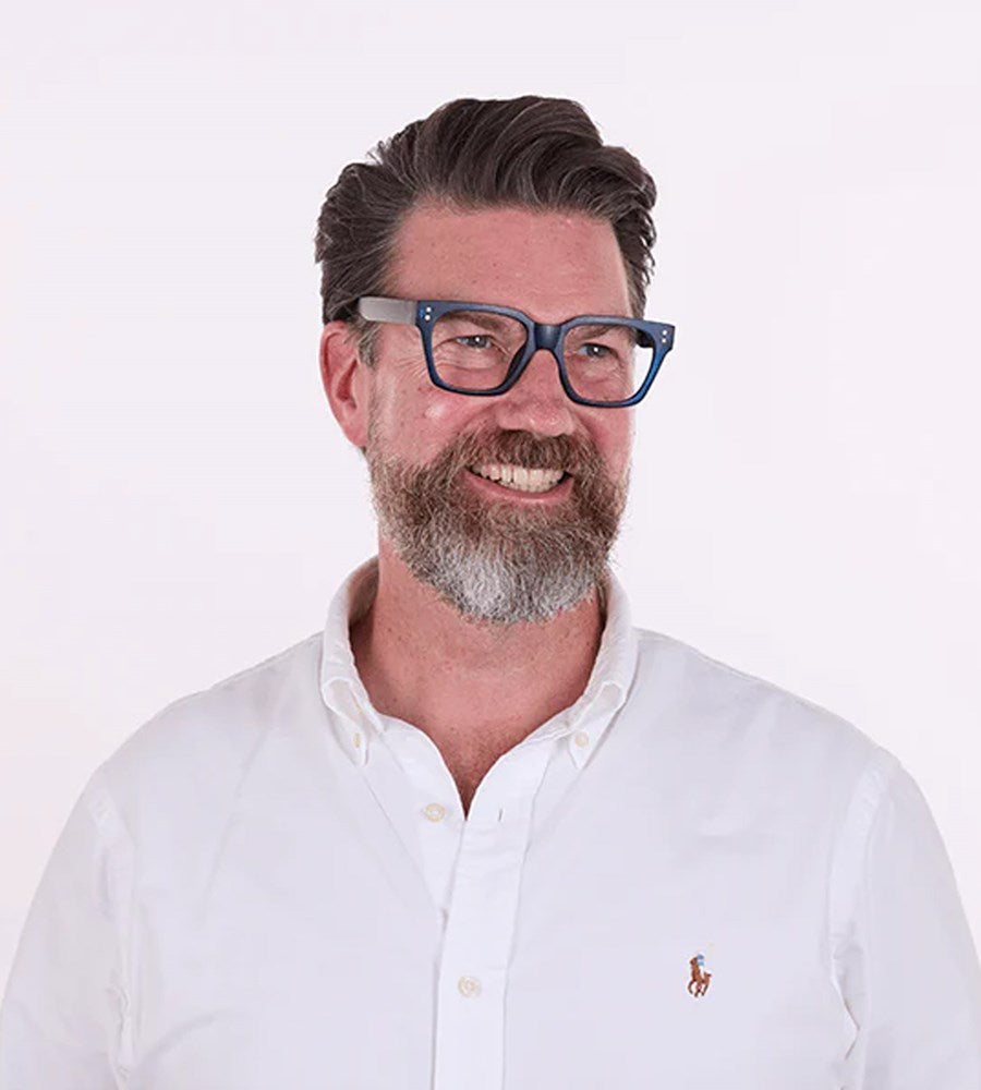 Man wearing blue glasses and a white shirt with a logo on a white background