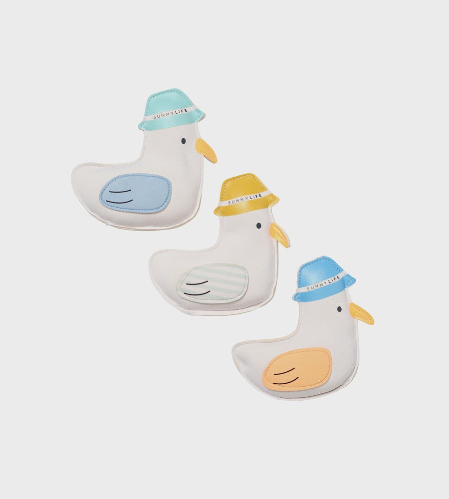 Three duck-shaped bath toys with colorful hats on a white background