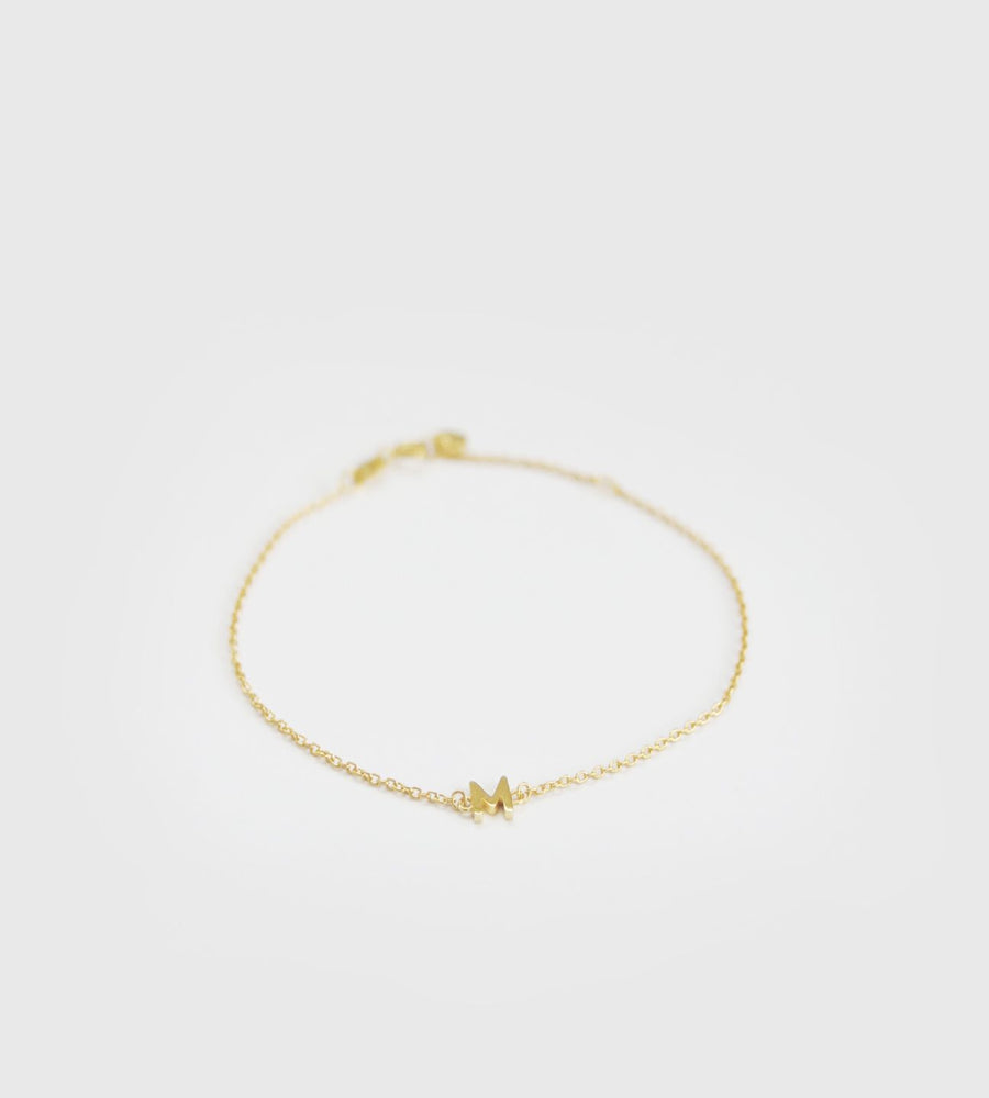 Gold bracelet on a light gray background