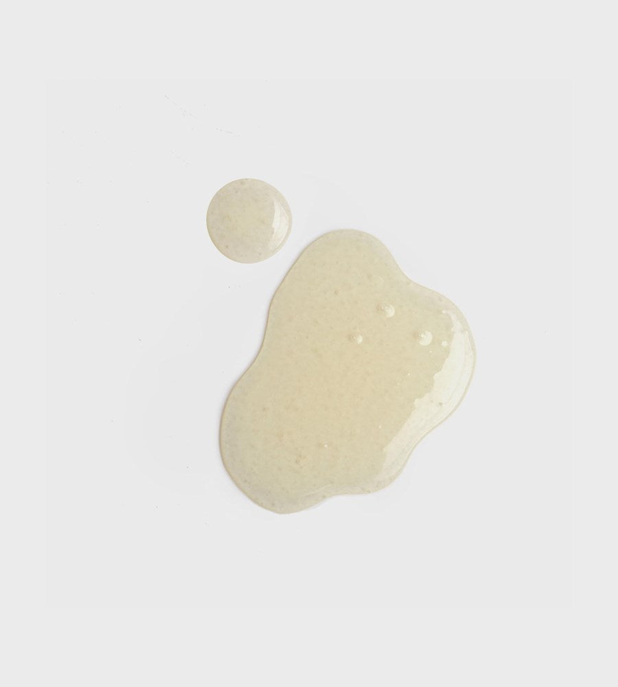 Beige liquid droplet and puddle on a light gray background