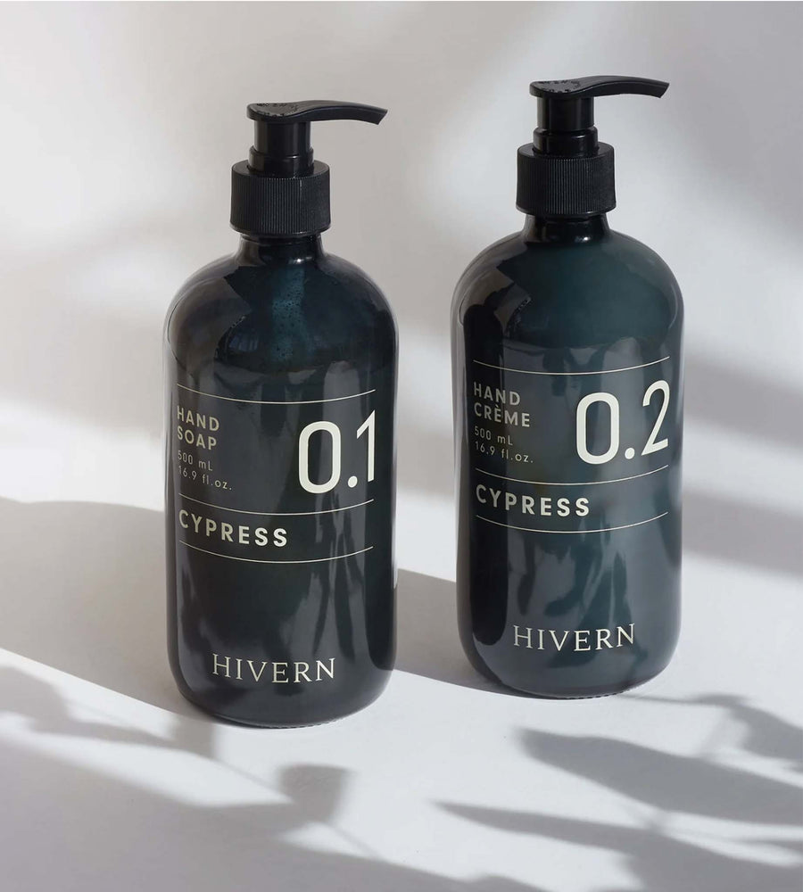 Two black bottles of Hivern hand soap and cream with pump dispensers on a light background.