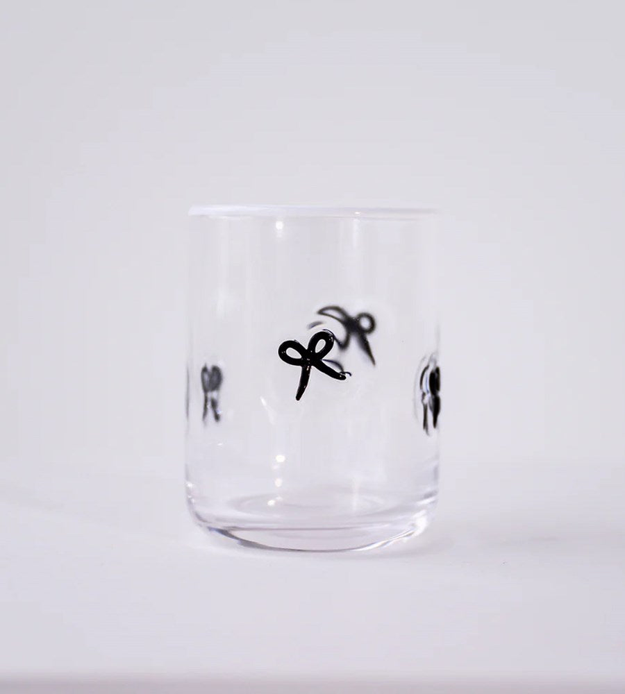 Clear glass tumbler with black illustrations on a white background