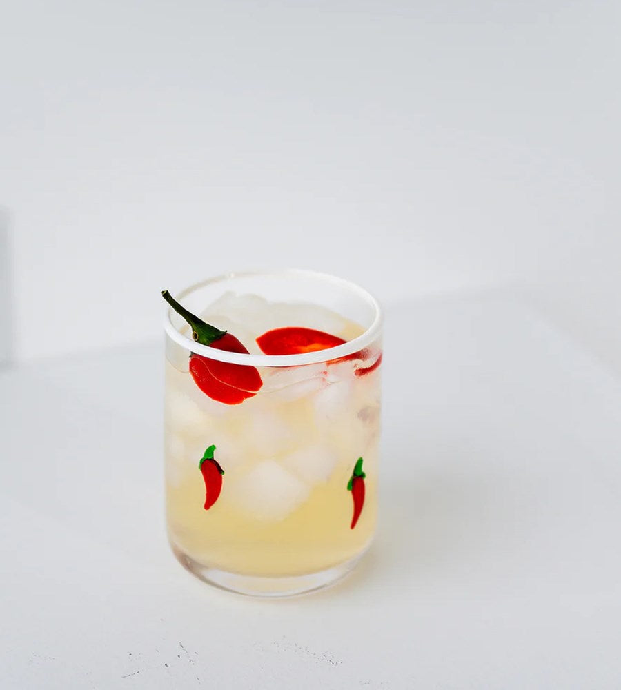 Glass of lemonade with ice and red peppers on a white background