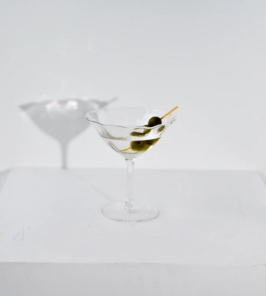 Martini glass with olive on a white background