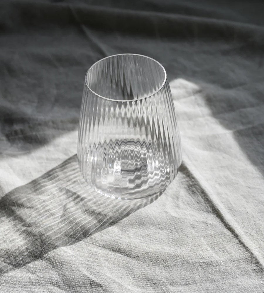 Clear glass tumbler on a textured fabric surface